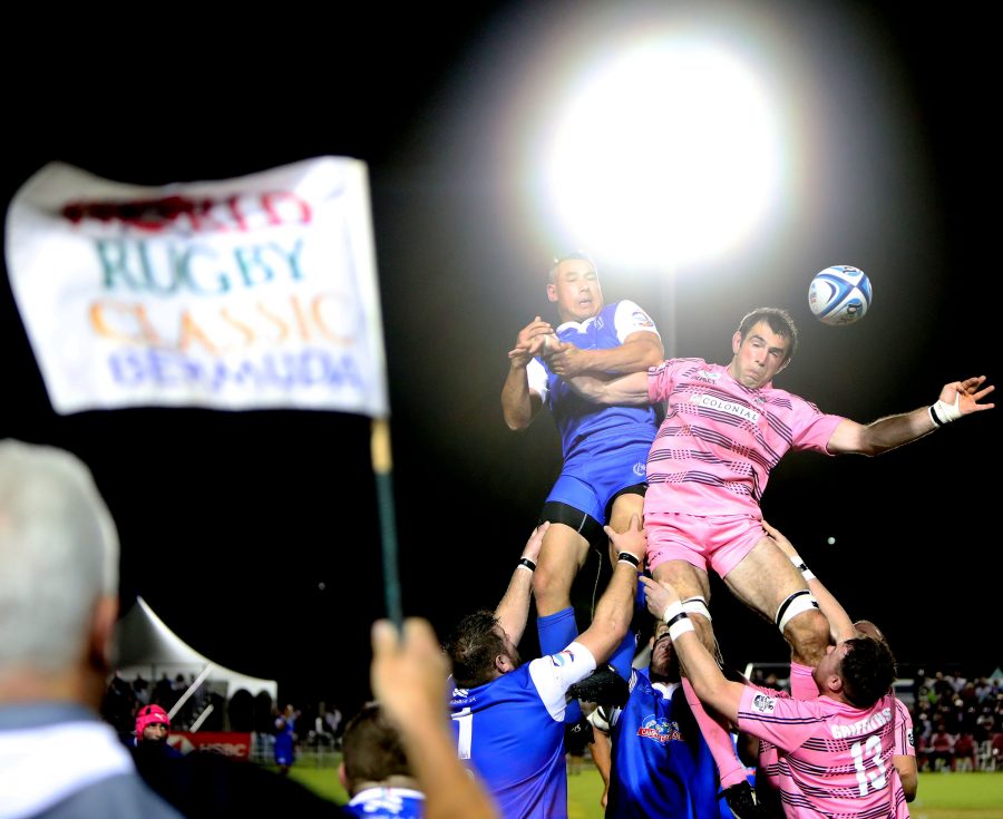 Men jump to catch a ball in a rugby match