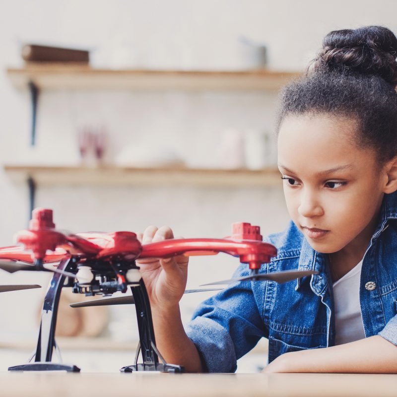 Little black girl playing with a drone