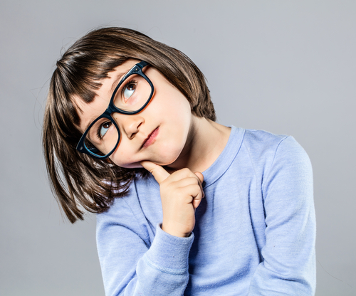 Little brunette girl with glasses thinking